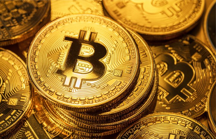 Mehrere Bitcoin-Münzen in Gold sind auf dem Bild zu sehen