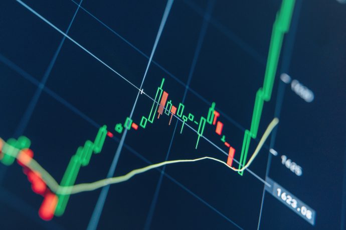 Ein digitales Aktienchart zeigt auf dunklem Hintergrund Kerzenmuster, eine gleitende Durchschnittslinie und eine starke Aufwärtsbewegung des Kurses, die von einer starken Basis ausbricht.