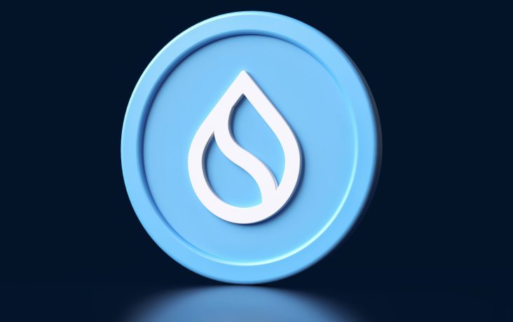 Eine blaue Münze zeigt in der Mitte ein weißes Wassertropfensymbol vor einem dunklen Hintergrund.