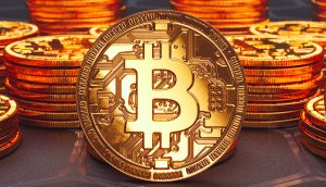Eine Nahaufnahme einer goldenen Münze mit dem Bitcoin-Symbol, die aufrecht zwischen Stapeln ähnlicher Münzen auf einer dunklen Fläche steht - perfekt zur Illustration einer Bitcoin-Prognose.