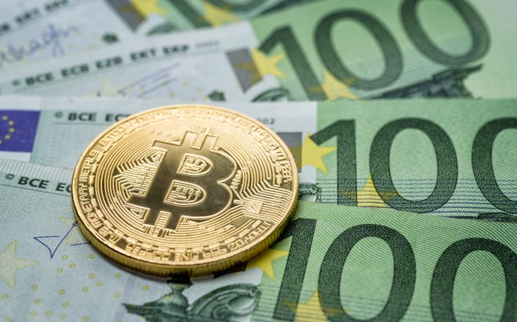 Das Bild veranschaulicht das Investieren von 1000 Euro in Bitcoin durch eine Bitcoin-Münze auf mehreren 100-Euro-Scheinen