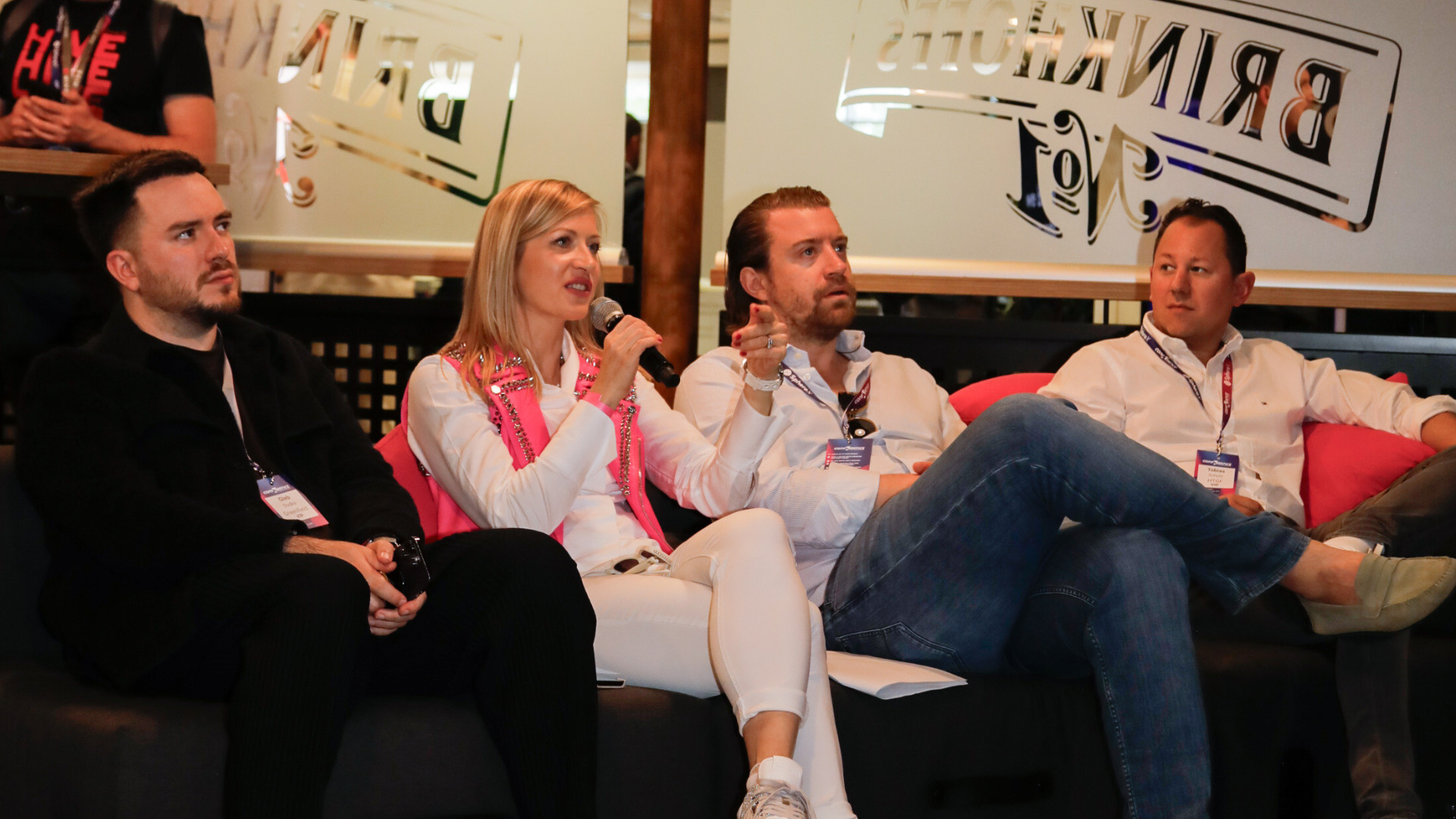 3 Vier Personen sitzen während einer Podiumsdiskussion zum Start-up Award in Dortmund auf einer Couch; eine Frau hält ein Mikrofon, während die anderen zuhören.