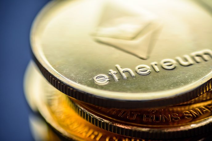 Nahaufnahme von gestapelten goldfarbenen Münzen mit dem Ethereum-Logo und dem Wort "Ethereum", das auf der Oberfläche eingraviert ist und das unverwechselbare Design dieser beliebten Kryptowährung hervorhebt.