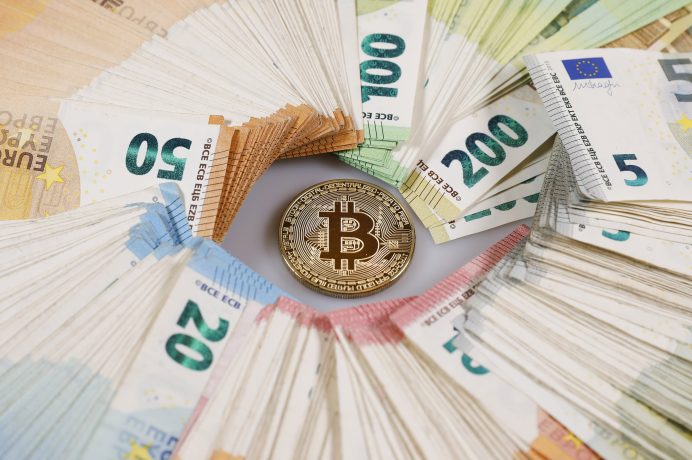 Stapel von Euro-Banknoten bildeten einen Kreis um einen einzelnen Bitcoin-Token in der Mitte und verdeutlichten so die Überschneidung von traditioneller Währung und Bitcoin.