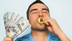 Ein Mann hält mehrere US-Hundert-Dollar-Scheine in der einen Hand und küsst mit der anderen eine goldene Bitcoin-Münze, wobei er vor einem schlichten hellen Hintergrund stolz seine Liebe zu Bitcoin zur Schau stellt.