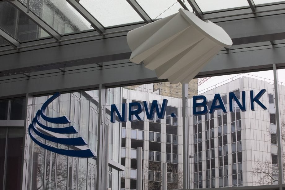 Gläsernes Bürogebäude mit NRW.BANK"-Schriftzug und blauem Logo, von innen gesehen; modernes, spiegelndes Äußeres durch die Fenster sichtbar - eine passende Kulisse für die innovative Blockchain-Anleihe der NRW.BANK.