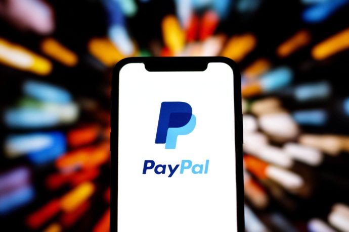 Ein Smartphone zeigt das PayPal-Logo auf seinem Bildschirm an, wobei ein verschwommener, farbiger Hintergrund nach außen strahlt, um die Präsenz von PayPal im Bereich der mobilen Zahlungen zu unterstreichen.