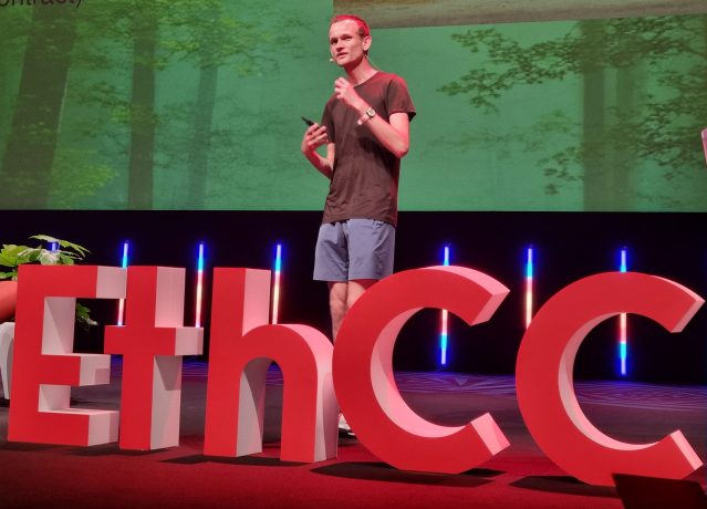Vitalik Buterin spricht auf der Bühne des EthCC, während im Hintergrund große rote EthCC-Buchstaben und eine Präsentationsfolie über statische HTML-Seiten, Ethereum und IPFS projiziert werden.