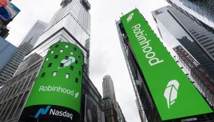 Grüne Robinhood-Anzeigen mit Blockchain-Themen werden auf großen digitalen Plakatwänden am Times Square in New York City gezeigt, wobei auf der linken Plakatwand ein Nasdaq-Zeichen zu sehen ist.