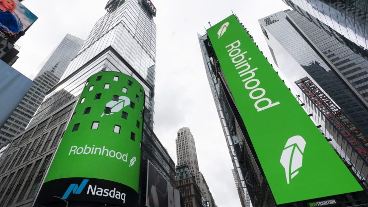 Grüne Robinhood-Anzeigen mit Blockchain-Themen werden auf großen digitalen Plakatwänden am Times Square in New York City gezeigt, wobei auf der linken Plakatwand ein Nasdaq-Zeichen zu sehen ist.