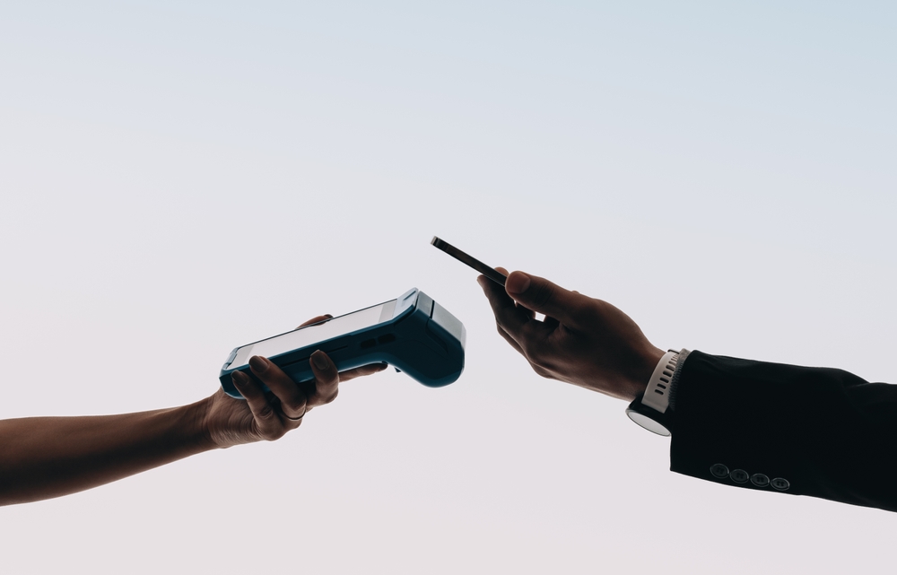 Kontaktlose Krypto-Zahlung mit Smartphone und Terminal – symbolisch für Binance Pay