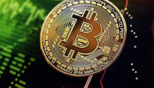 Eine physische Darstellung eines Bitcoins liegt auf einem digitalen Hintergrund mit grünen und roten Markttrendlinien und Kurscharts.