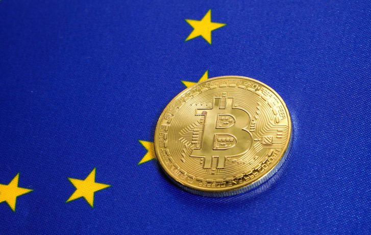 Eine goldene Bitcoin-Münze auf einer Flagge der Europäischen Union mit gelben Sternen auf blauem Hintergrund, die die mögliche Einführung eines Bitcoin-ETF in Europa symbolisiert.
