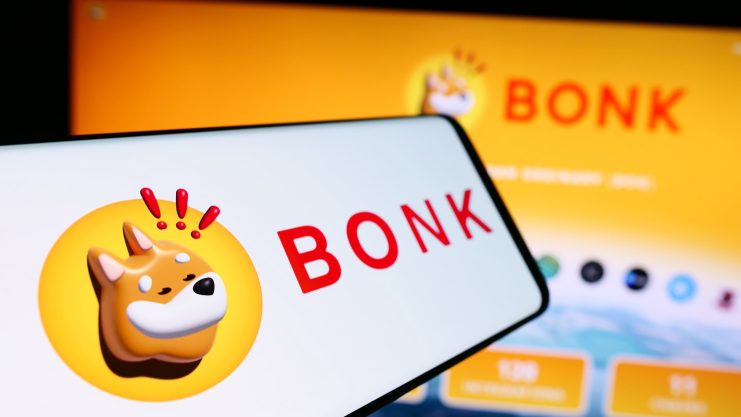 Auf einem Smartphone und einem Computerbildschirm ist das BONK-Logo zu sehen, das einen verspielten Shiba-Inu-Kopf neben dem fetten roten BONK-Text zeigt.