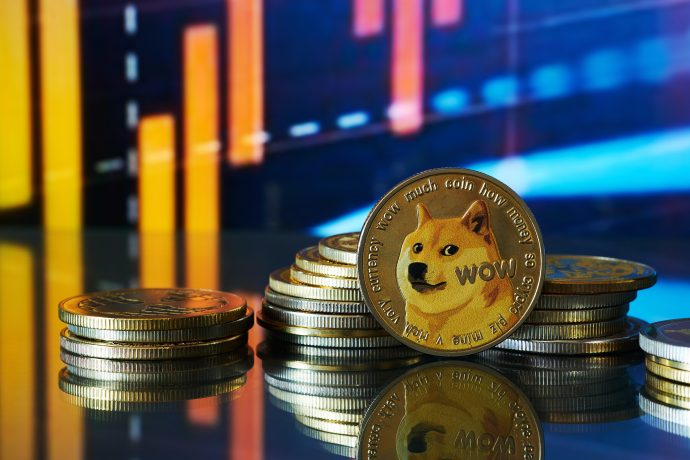 Stapel von Dogecoin-Münzen werden auf einer reflektierenden Oberfläche angezeigt, wobei ein digitales Dogecoin-Finanzdiagramm den Hintergrund beleuchtet.