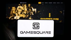 Eine Person hält ein Smartphone mit dem GameSquare-Logo vor einem Computerbildschirm, der die GameSquare-Website zeigt und die Integration mit Ethereum hervorhebt.