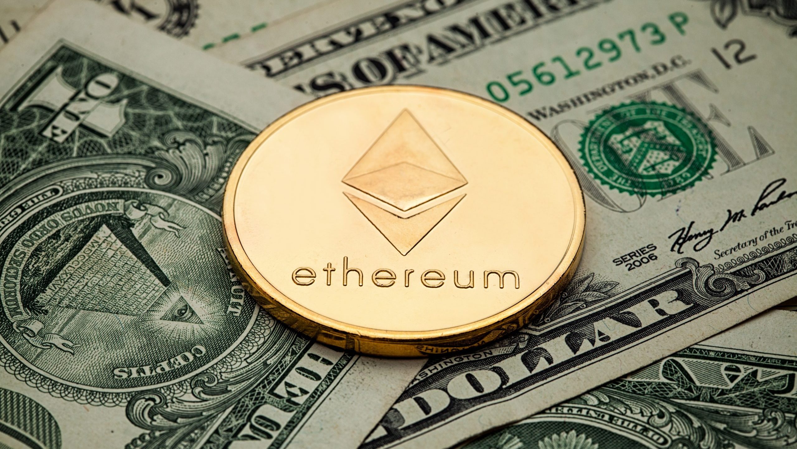 Eine goldene Ethereum-Münze sitzt auf mehreren US-Ein-Dollar-Scheinen und verdeutlicht die Überschneidung von Ethereum und traditioneller Währung.