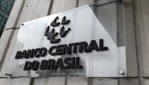 Ein Schild an einer Betonmauer mit der Aufschrift Banco Central do Brasil und einem geometrischen Logo über dem Text weist auf diese wichtige Institution hin, die häufig in Diskussionen über finanzielle Sicherheit und Hackerschutz erwähnt wird.