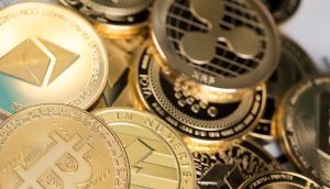 Eine Nahaufnahme von verschiedenen physischen Münzen mit Krypto-Logos, darunter Bitcoin, Ethereum und Ripple.