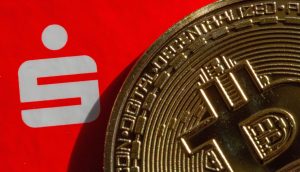 Eine Nahaufnahme einer Bitcoin-Münze neben einem weißen Logo, das einem stilisierten S auf rotem Hintergrund ähnelt und die Essenz von Krypto-News DACH einfängt.