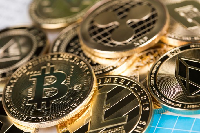 Eine Nahaufnahme von mehreren physischen Münzen, die verschiedene Kryptowährungen repräsentieren, darunter Bitcoin, Litecoin, Ethereum und Ripple, die in einem Stapel angeordnet sind, um die vielfältige Welt der Kryptowährungen zu symbolisieren.
