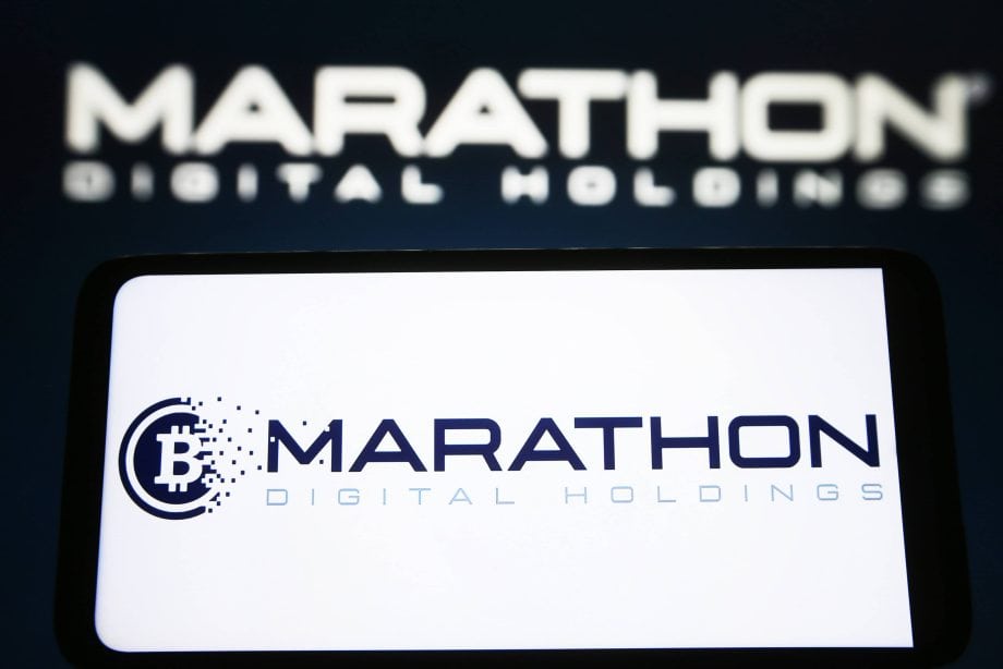 Auf einem Bildschirm wird das Logo von MARA Marathon Digital Holdings angezeigt, mit einem verschwommenen Firmennamen im Hintergrund.