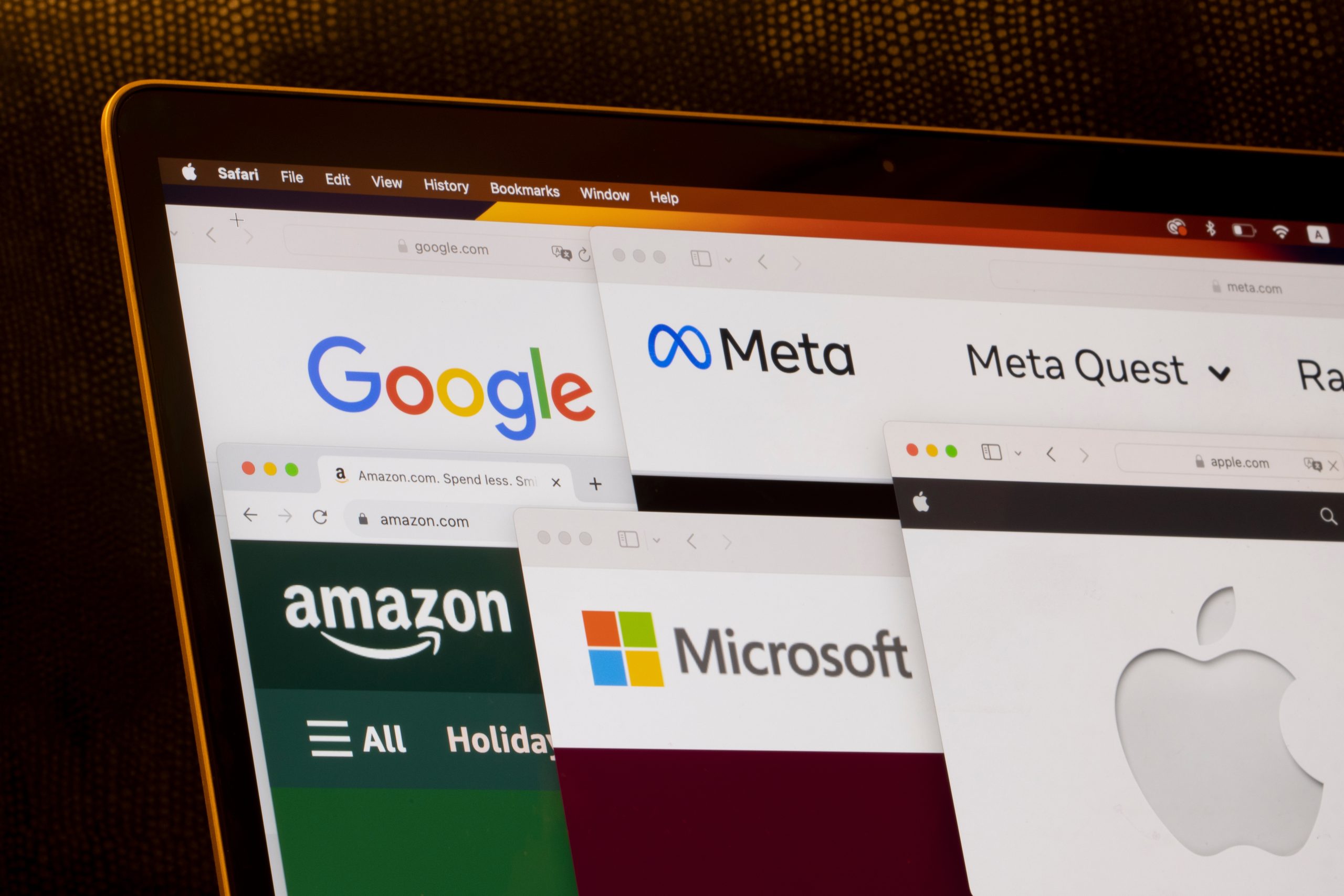 Laptop-Bildschirm mit überlappenden Browser-Registerkarten, die die Logos von Google, Meta, Amazon, Microsoft Aktie, Apple und Meta Quest auf ihren jeweiligen Websites zeigen.