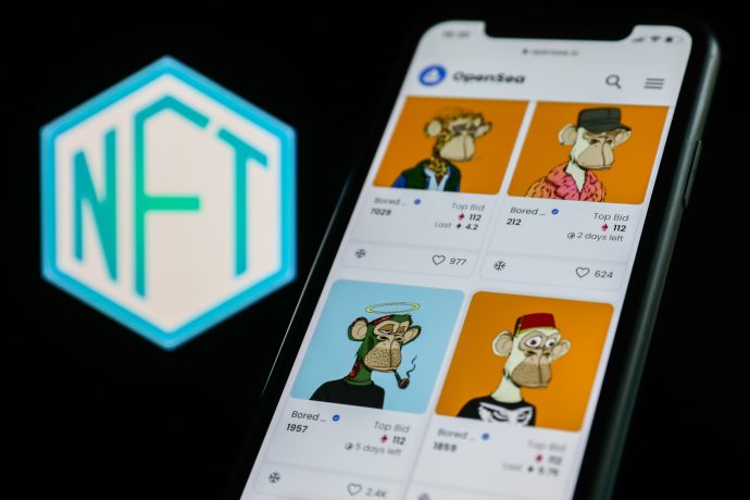 Ein Smartphone zeigt die NFTs des Bored Ape Yacht Clubs auf OpenSea an, mit einem deutlich sichtbaren NFT-Logo im Hintergrund.