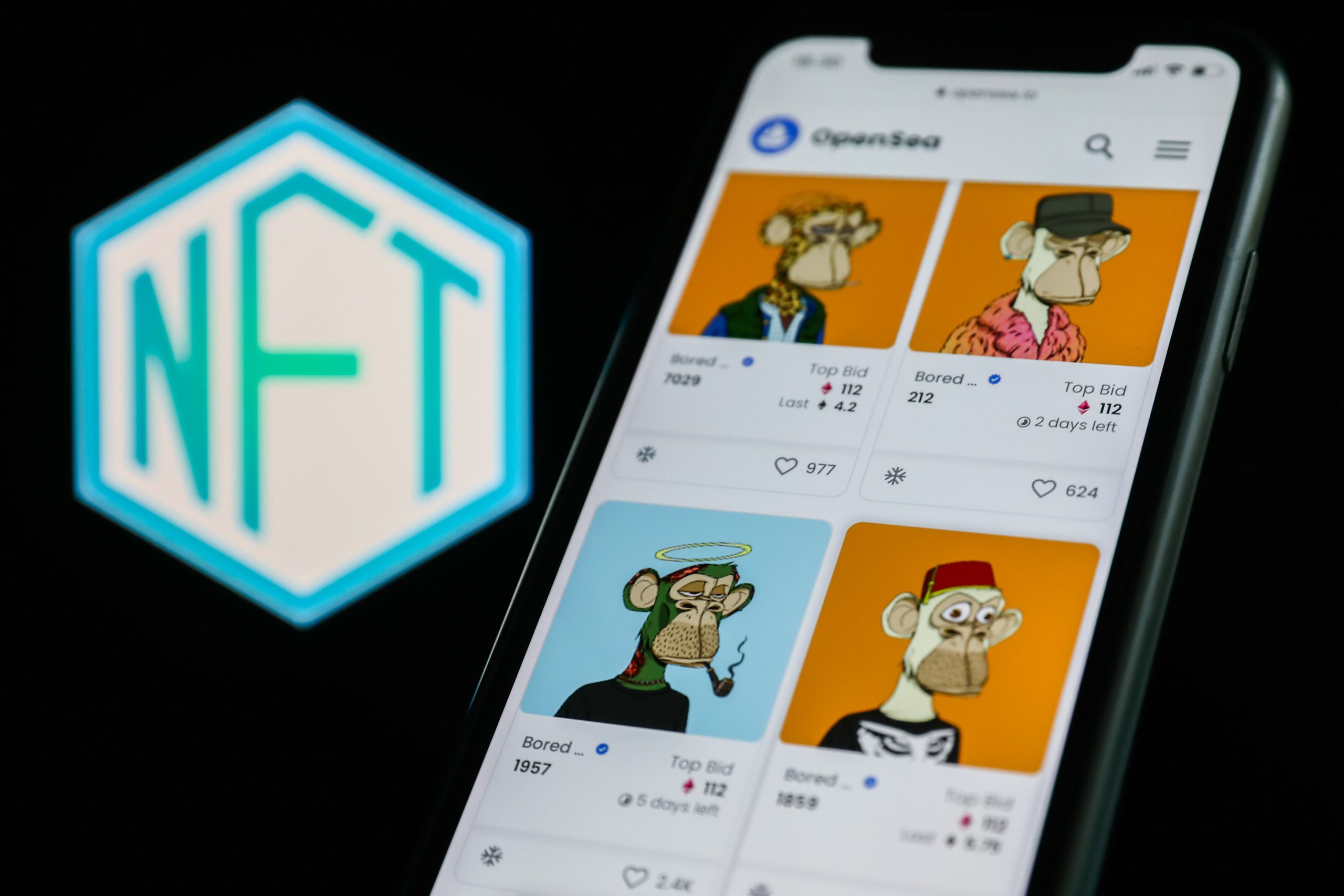 Ein Smartphone zeigt die NFTs des Bored Ape Yacht Clubs auf OpenSea an, mit einem deutlich sichtbaren NFT-Logo im Hintergrund.