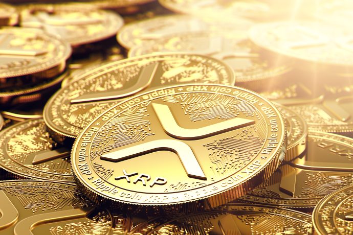 Eine Nahaufnahme mehrerer goldfarbener XRP-Kryptowährungsmünzen mit dem Ripple-Logo und kreisförmigen Mustern auf der Oberfläche, die vom Sonnenlicht beleuchtet werden - eine Anspielung auf das laufende Gerichtsverfahren von Ripple mit der SEC.