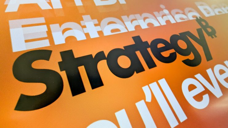 Nahaufnahme von fett gedrucktem, sich überlappendem Text auf orangefarbenem Hintergrund, mit dem hervorstechenden Wort Strategie in Schwarz und anderen Wörtern wie Ansatz und Plan in Weiß und Orange.