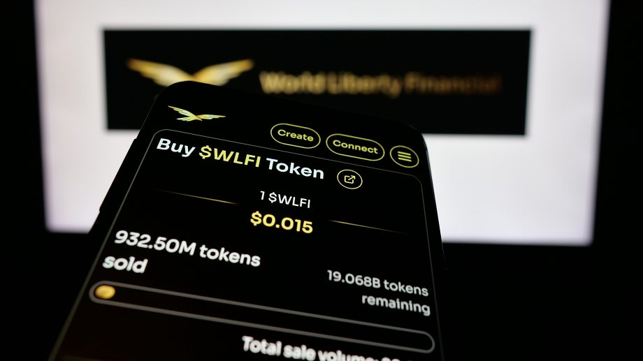 Ein Smartphone-Bildschirm zeigt die Option zum Kauf von WLFI-Token zu je $0,015 an. Es werden 932,50 Millionen Token verkauft und 19,07 Millionen WLFI-Token verbleiben. Im Hintergrund ist das World Liberty Financial-Logo zu sehen.