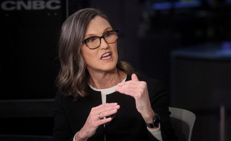 Eine Frau mit Brille und schulterlangem Haar spricht während eines Fernsehinterviews mit Gesten über Krypto-Aktien. Im Hintergrund ist ein CNBC-Logo zu sehen.