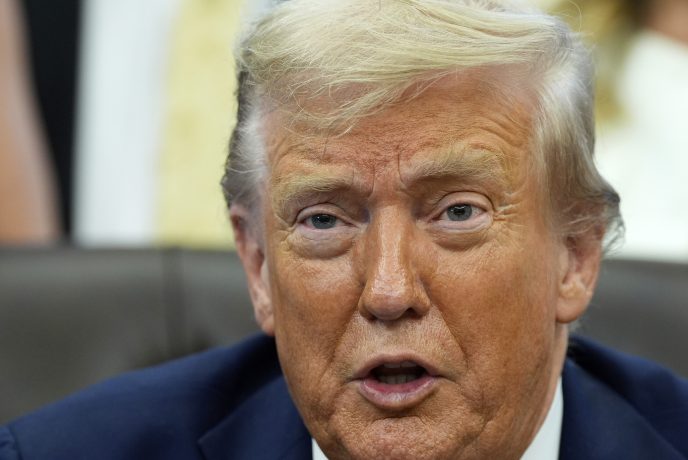 Nahaufnahme von Donald Trump mit hellem Haar und Anzug, der in einem Haus sitzt und leicht zur Seite blickt, wobei sein Mund teilweise geöffnet ist - vielleicht bespricht er einen aktuellen Rekord der Trump Media Group.