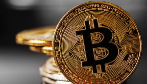 Eine Nahaufnahme einer physischen Bitcoin-Münze mit dem Bitcoin-Logo, gestapelt mit anderen ähnlichen Münzen im Hintergrund, fängt einen Moment ein, in dem der Bitcoin-Preis während einer Marktkorrektur stagniert.