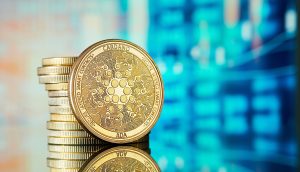 Ein Stapel Cardano-Münzen liegt auf einer spiegelnden Oberfläche, mit einer unscharfen digitalen Karte im Hintergrund.