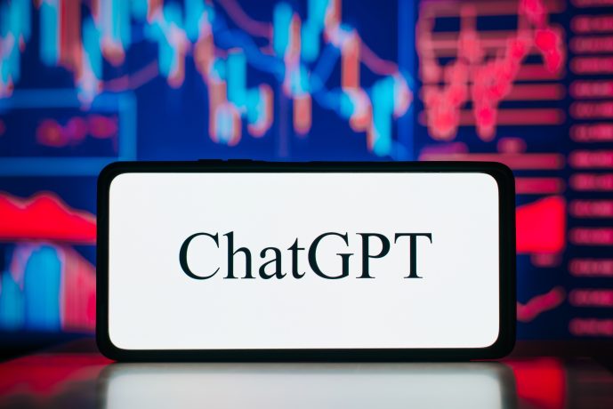 Ein Smartphone, auf dessen Bildschirm das Wort ChatGPT erscheint, mit bunten Finanzgrafiken, Ethereum-Trends und verschwommenen Aktiencharts im Hintergrund.
