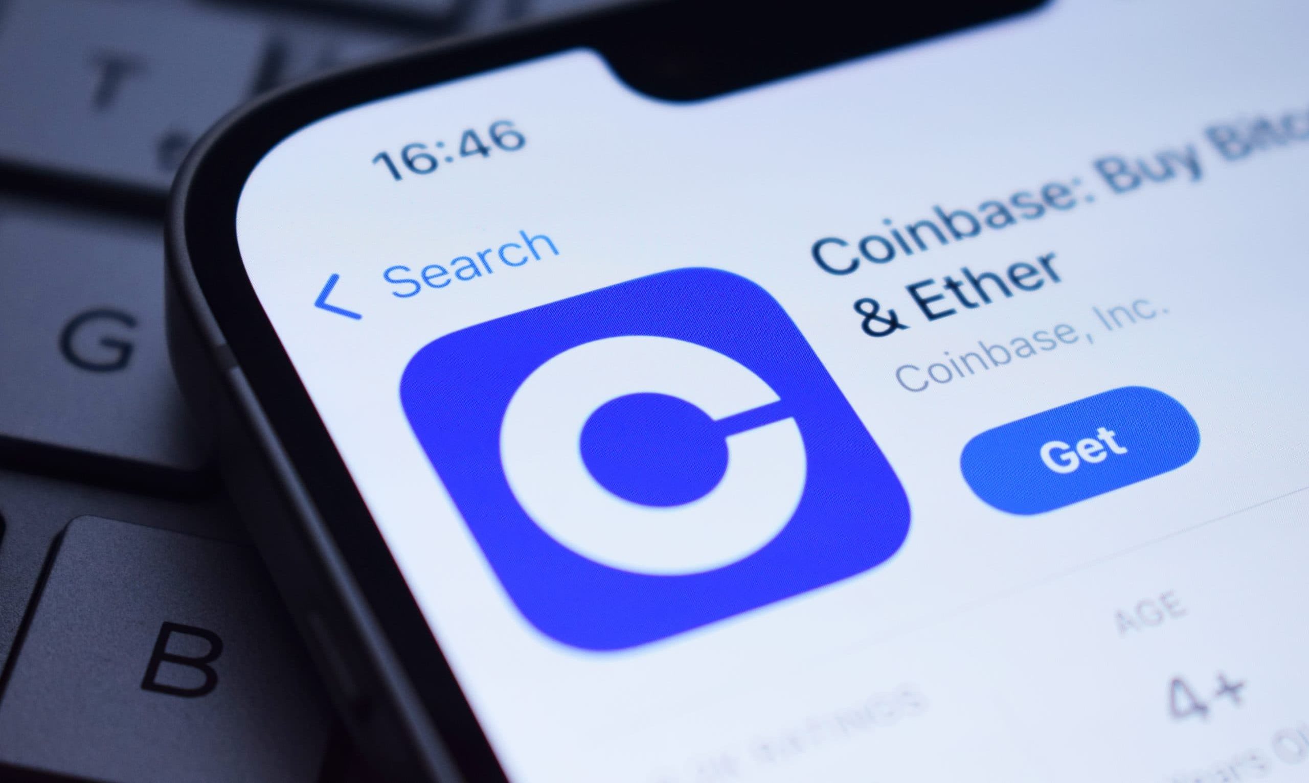 Nahaufnahme eines Smartphone-Bildschirms, der die Coinbase-App-Seite mit der Option, Coinbase zu erhalten, auf einer Tastatur anzeigt.