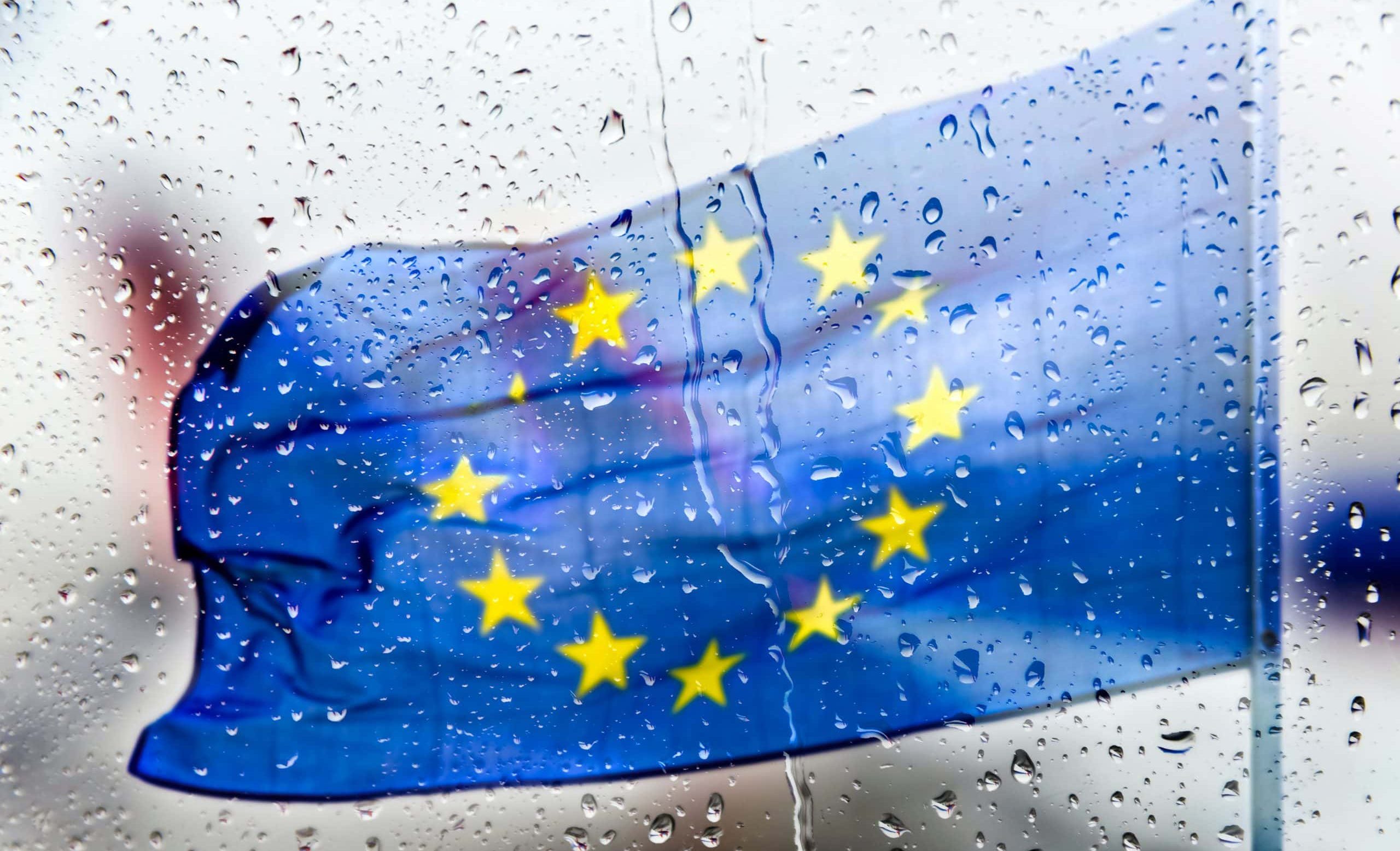 EU-Flagge hinter regennasser Scheibe als Symbolbild für Euro-Stablecoins, MiCA und Europas digitale Geldpolitik