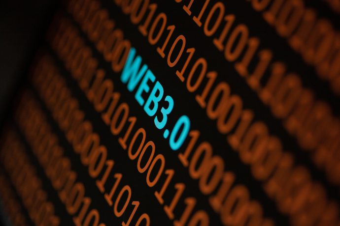 Die Phrase Web3.0 erscheint in blauer Schrift zwischen Reihen von orangefarbenem Binärcode auf schwarzem Hintergrund und hebt die Entstehung der Web3-Technologie hervor.