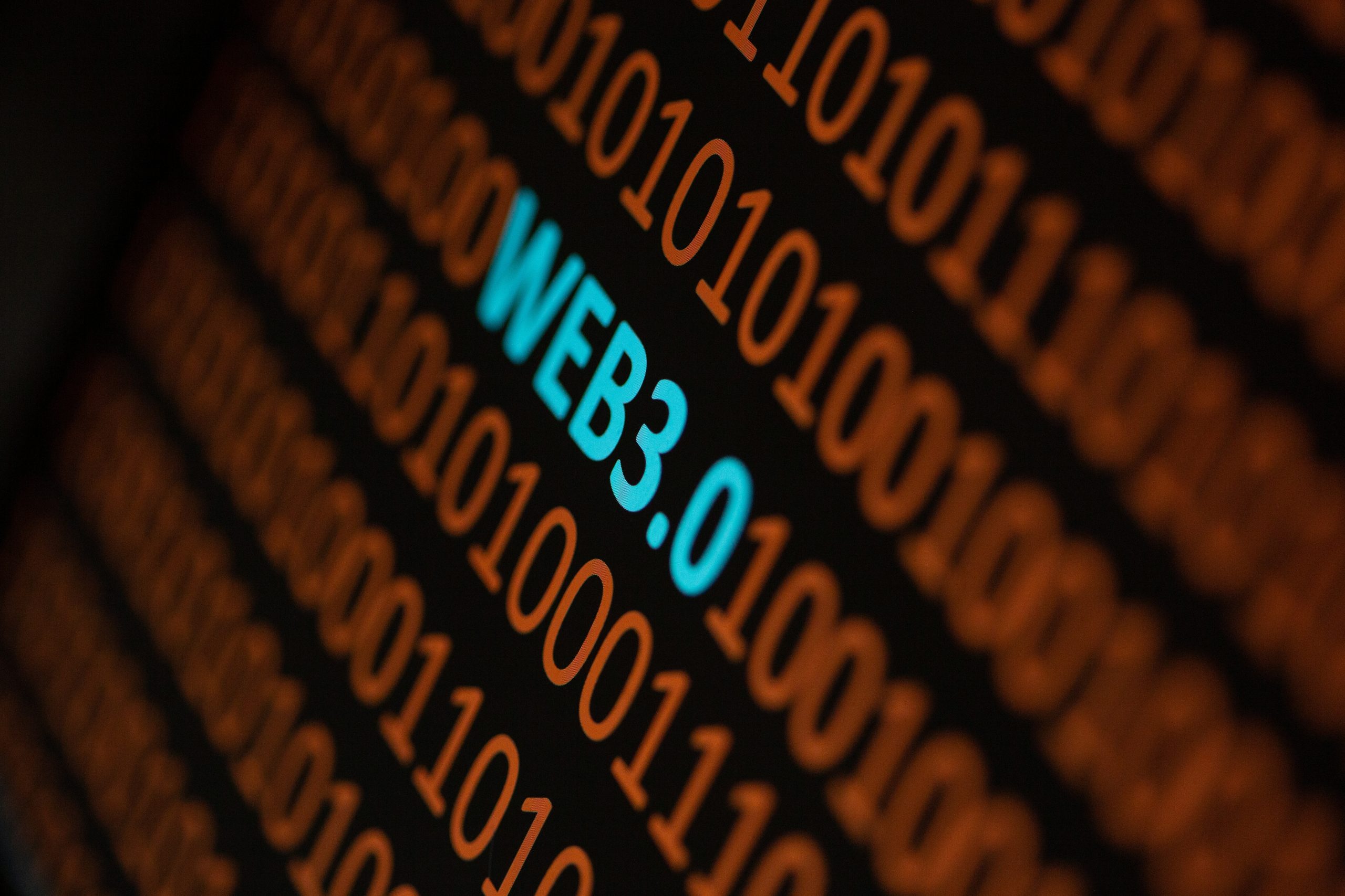 Die Phrase Web3.0 erscheint in blauer Schrift zwischen Reihen von orangefarbenem Binärcode auf schwarzem Hintergrund und hebt die Entstehung der Web3-Technologie hervor.