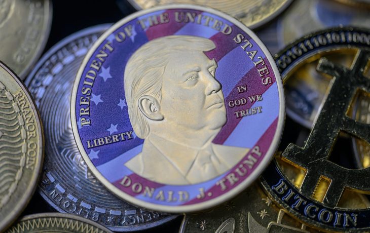 Gedenkcoin mit Donald-Trump-Porträt als Symbolbild für World Liberty Financial (WLFI) und den Trump Coin inmitten anderer Kryptowährungen wie Bitcoin.