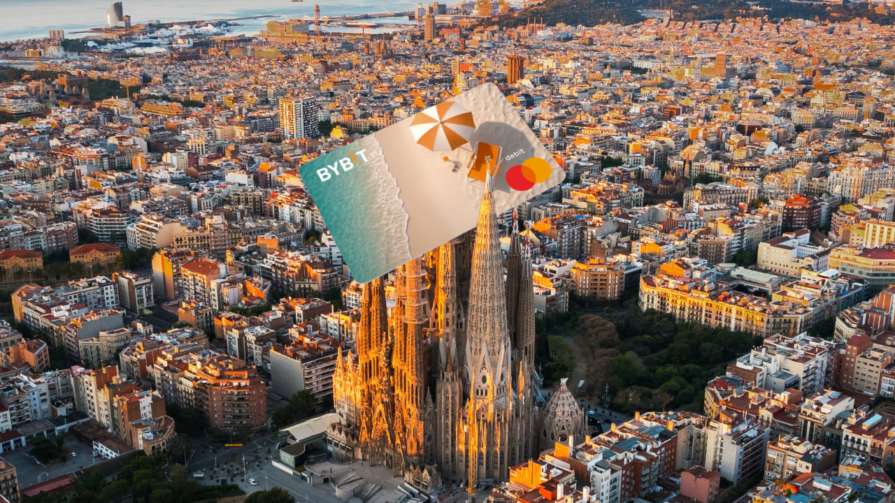 Luftaufnahme der Sagrada Familia in Barcelona mit überdimensionalen Bybit-Karten, die digital über der Basilika eingeblendet werden.