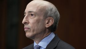 Gary Gensler in Anzug und Krawatte mit ernstem Gesichtsausdruck ist im Profil vor einem dunklen Hintergrund abgebildet und ähnelt Gary Gensler.