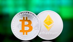 Zwei physische Münzen, darunter eine, die Ethereum repräsentiert, werden nebeneinander vor einem verschwommenen grünen und blauen Hintergrund angezeigt.