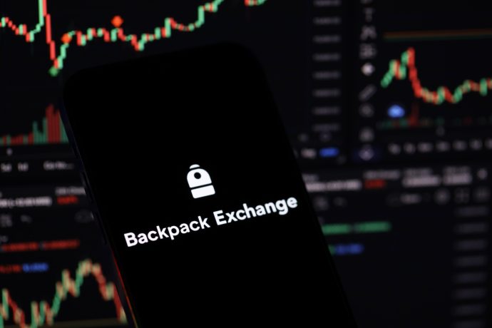 Auf einem Smartphone-Bildschirm werden das Logo und der Name der Backpack Exchange angezeigt. Im Hintergrund sind unscharfe Charts für den Handel mit Kryptowährungen und der Perpetuals-Handel zu sehen, was die Präsenz der Börse als führende KryptoBörse in Europa unterstreicht.