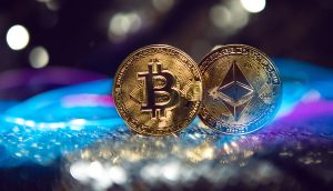 Zwei physische Münzen mit dem Bitcoin- und dem Ethereum-Logo werden nebeneinander auf einer spiegelnden Oberfläche angezeigt, wobei verschwommene Lichter im Hintergrund elegant leuchten.