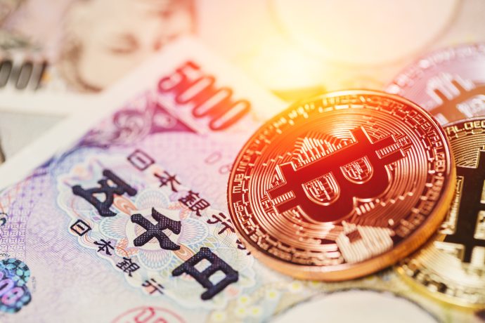 Eine physische Bitcoin-Münze auf japanischen Yen-Banknoten, einschließlich einer 5.000-Yen-Note, bei warmer Beleuchtung - ein Bild, das die Vision von Metaplanet für Bitcoin-Rendite im Jahr 2025 widerspiegelt.
