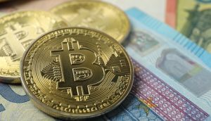 Nahaufnahme von physischen Bitcoin-Münzen auf Euro-Banknoten, die die Beziehung zwischen Krypto und traditioneller Währung symbolisieren.
