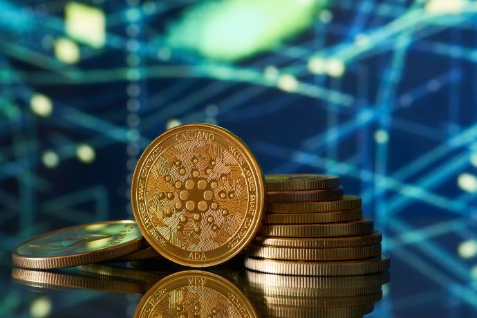 Ein Stapel goldfarbener Cardano (ADA)-Kryptowährungsmünzen wird vor einem digitalen abstrakten Hintergrund mit blauen und gelben Lichtlinien gezeigt, der den innovativen Geist von Cardano hervorhebt.
